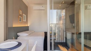 A hotel room with a bed, a dining table, and a small kitchenette. - Studio com Piscina Perto do Metr Vila Mariana (São Paulo)