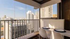 Ein Balkon mit Essplatz und Blick auf die Stadt.