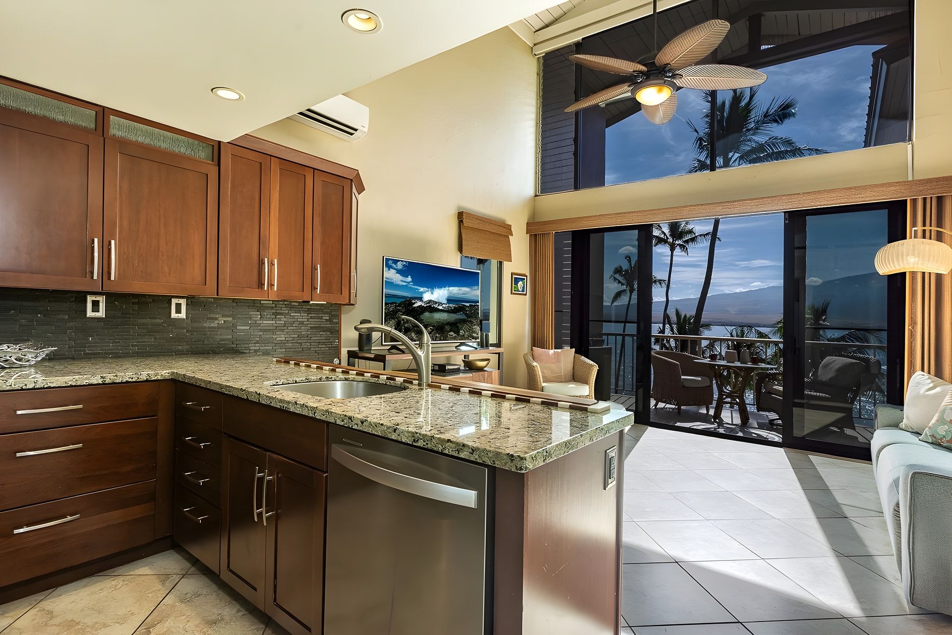 A spacious kitchen with granite countertops, wooden cabinets, and a large island with a sink.