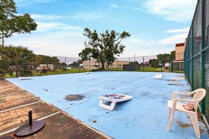 Ein Sportplatz im Freien mit blauer Spielfläche, weißen Bänken und einem Tisch von GoSports.