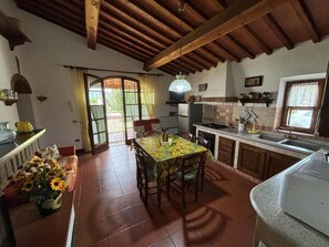 A kitchen with a dining table, chairs, a refrigerator, and a sink. - Sant'Ignazio Farm (Toscana)