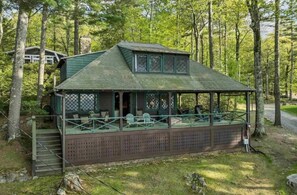 Una baita con un portico coperto, una scala che conduce all'ingresso e vista sulla foresta circostante.
