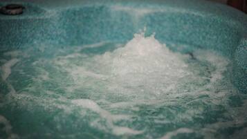 Un bain à remous doté de jets d’eau visibles qui créent une surface en mouvement.