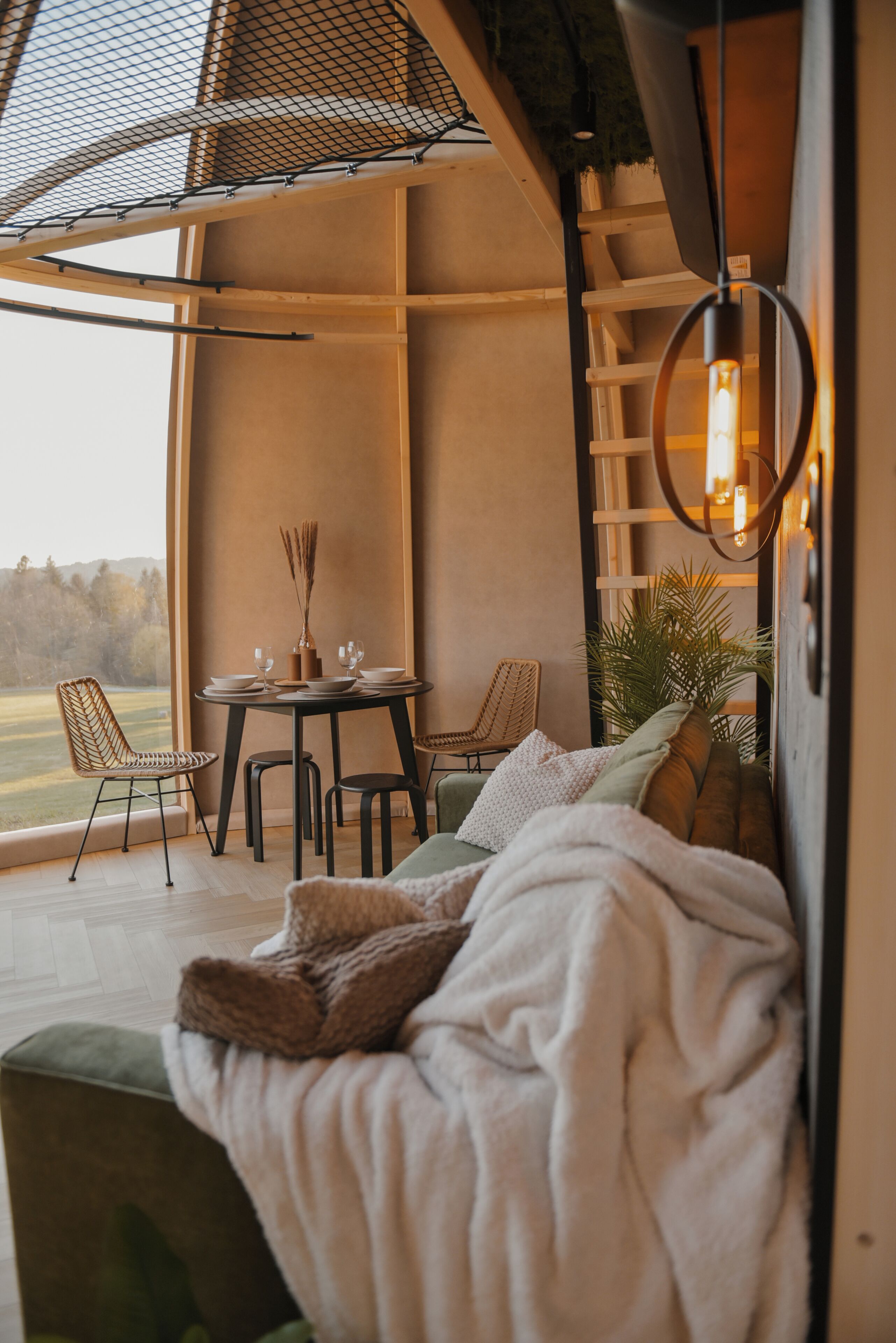 Un coin salon confortable avec un canapé, des fauteuils et une table dressée pour les repas, offrant une vue panoramique.