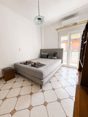 Ein Schlafzimmer mit Bett, Nachttisch, Lampe und einem Fenster mit Blick.