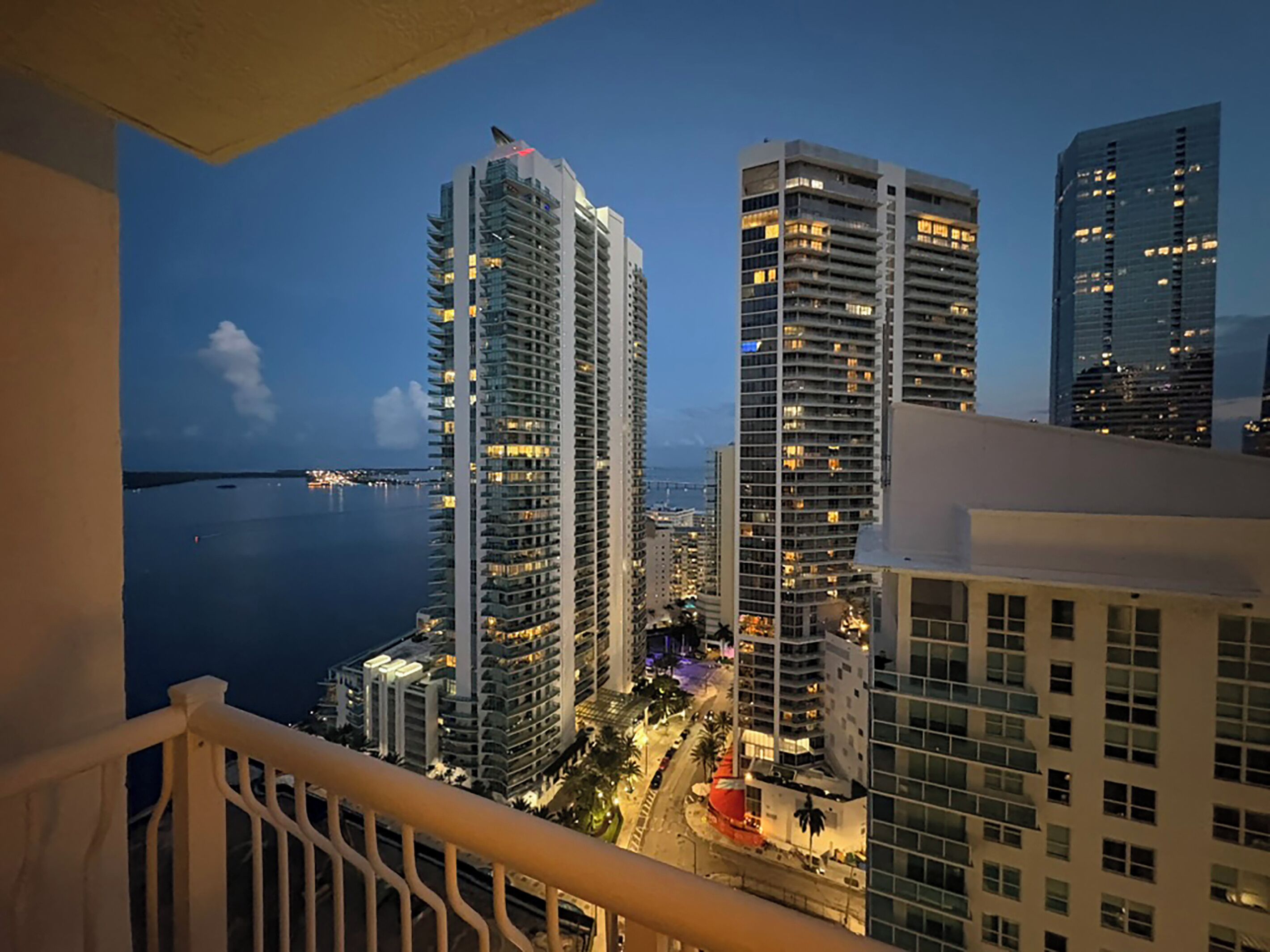 A high-rise building complex with multiple floors, a waterfront view, and a bridge in the background.