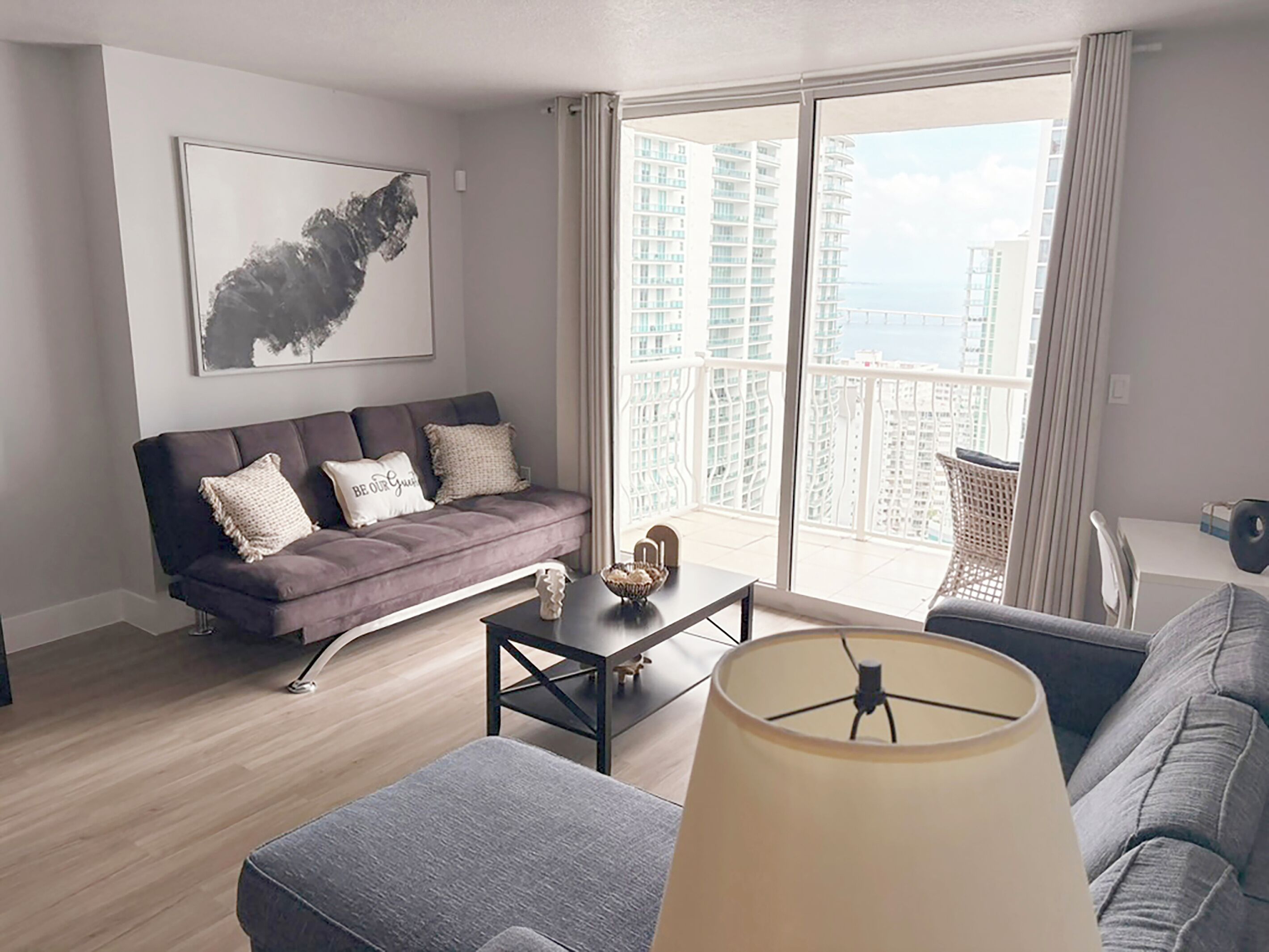 A modern living room with a sofa, a coffee table, and a lamp.