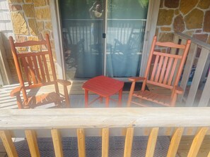 A wooden deck with two chairs and a small table. - JAMBO @ Cades Cove Landing Unit 110 (Townsend)