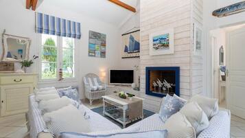 Una sala de estar acogedora con sofá, televisor y chimenea.