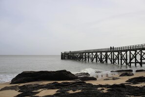 A pier extending into calm waters, surrounded by rocks and sandy beach. - Joli Villa | Proche de la plage + Parking Gratuit (St Jean de Monts – France)
