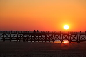 A pier extending into the water with a sunset in the background. - Charmante Villa équipée pour 8 + Parking Gratuit (St Jean de Monts – France)
