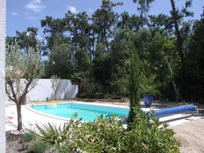 A swimming pool surrounded by trees and plants. - Charmante Villa équipée pour 8 + Parking Gratuit (St Jean de Monts – France)