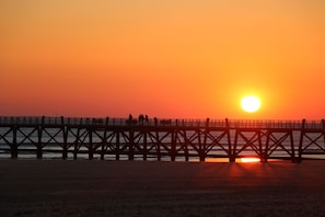 A pier extending into the water with a sunset in the background. - Charmante Villa pour 6 | Proche de la plage! (St Jean de Monts – France)