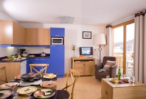 A compact living space with a kitchenette, dining area, and a seating area with a view.