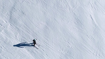 Pendenza innevata con uno sciatore.