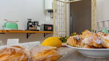 Una cucina con macchina del caffè, tostapane e frigorifero.