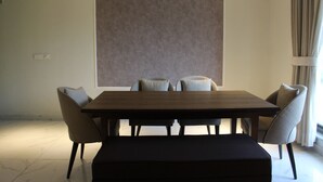 Ein moderner Essraum mit einem rechteckigen Tisch, sechs Stühlen und einem großen abstrakten Gemälde an der Wand.