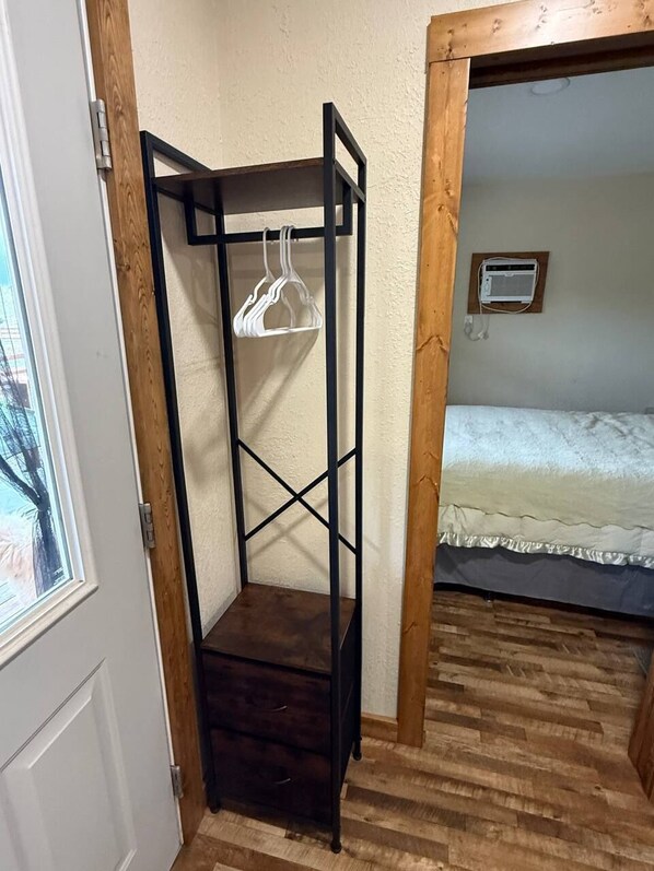 A room with a bunk bed, a wooden wardrobe, and a window.