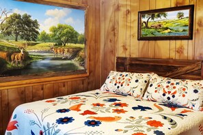 A room with a bed, a large window with a painting of a landscape, and a smaller framed painting on the wall. - Enjoy Longhorns at Texas Ranch House near Canyon Lake & Gruene – Sleeps 12 (New Braunfels)