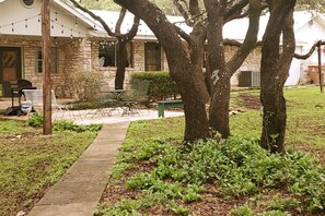 A residential property with a stone facade, a front yard with a pathway, and a green lawn.