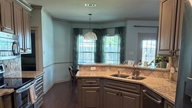 A spacious kitchen with a large island, built-in appliances, and a patterned rug. - Gig'em Getaway Pool House - Sleeps 10 (Bryan)
