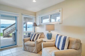 A living room with two sofas, a lamp, and a view of a deck and mountains. - Bernard's Best - Spacious 4-bedroom townhome on Smith Mt Lake (Moneta)