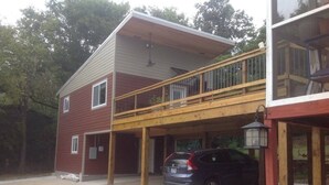 A two-story building with a covered parking area and a car parked inside. - Downtown Bohemian Bungalow Full Bed Bottom TwinTop (Fayetteville)