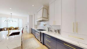 A modern kitchen with marble countertops, stainless steel appliances, and gold handles on cabinets. - Executive Home in Toronto [4 bedrooms\4 Bath] (Toronto)