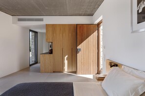 Ein modernes Schlafzimmer mit einem großen Bett, einem Holzschrank und einer Steinwand.