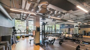 Una palestra con attrezzature per allenamento, rastrelliere per pesi e diverse macchine.