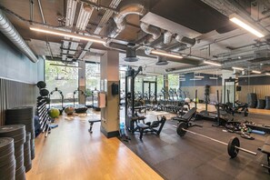Ein Fitnessstudio mit Trainingsgeräten, Gewehrgestellen und verschiedenen Maschinen.