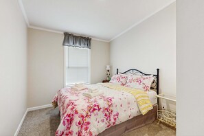 A bedroom with a bed, a window with blinds, a bedside table, and a lamp. - Blackhawk Retreat- Near Lakes, Trails & Golf (Arkdale)