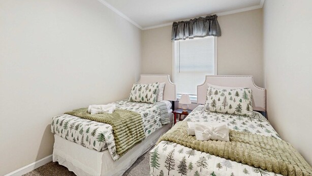 Quarto com duas camas de solteiro, janela com persianas e mesa de cabeceira com abajur.