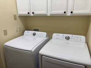 A laundry room with two front-loading washing machines and a cabinet above them. - 2BR, 1 1/2Ba, Kitch, TV rm, laundry rm, 2 patios w full views the Tellico Lake. (Loudon)
