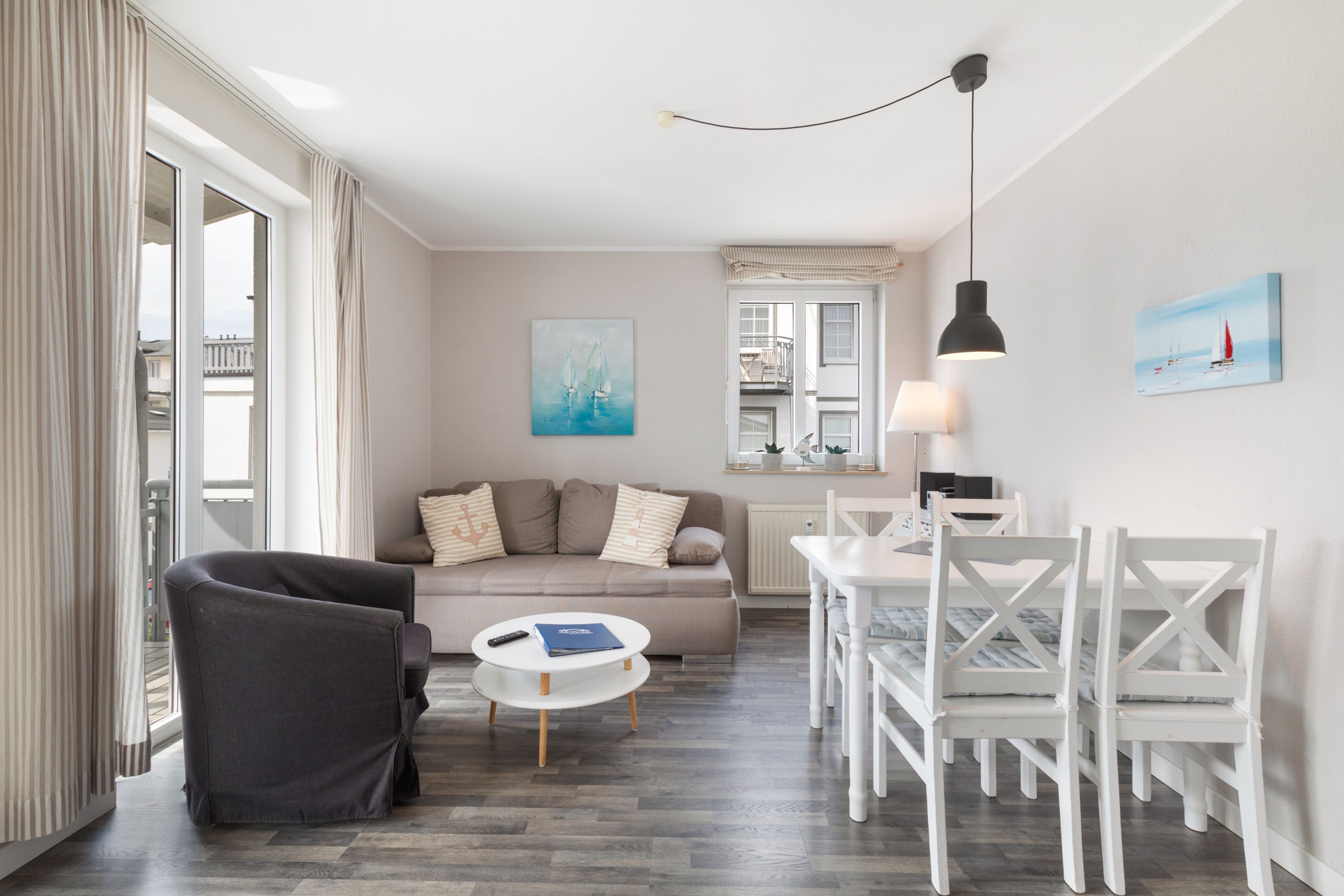 Ein modernes Wohnzimmer mit einer Couch, einem Couchtisch und einem Essbereich mit Stühlen.