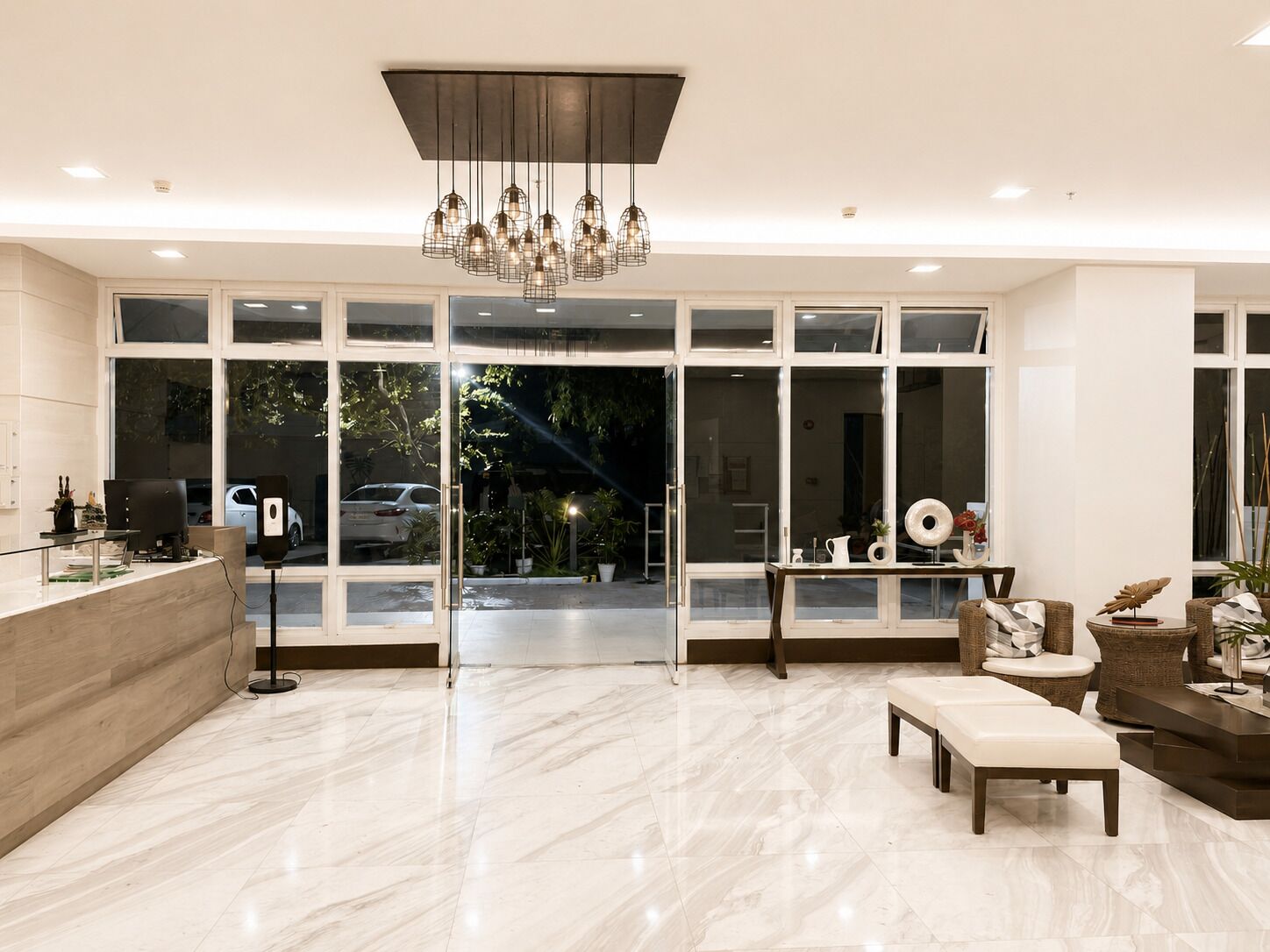 A spacious lobby with a reception desk, seating area, and large windows offering a view of the outdoors.