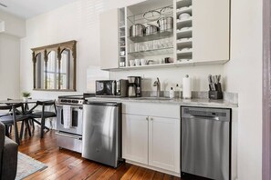 A modern kitchen with stainless steel appliances, a coffee maker, and a dish rack. - 2BR Historic Charleston Getaway - C (Charleston)