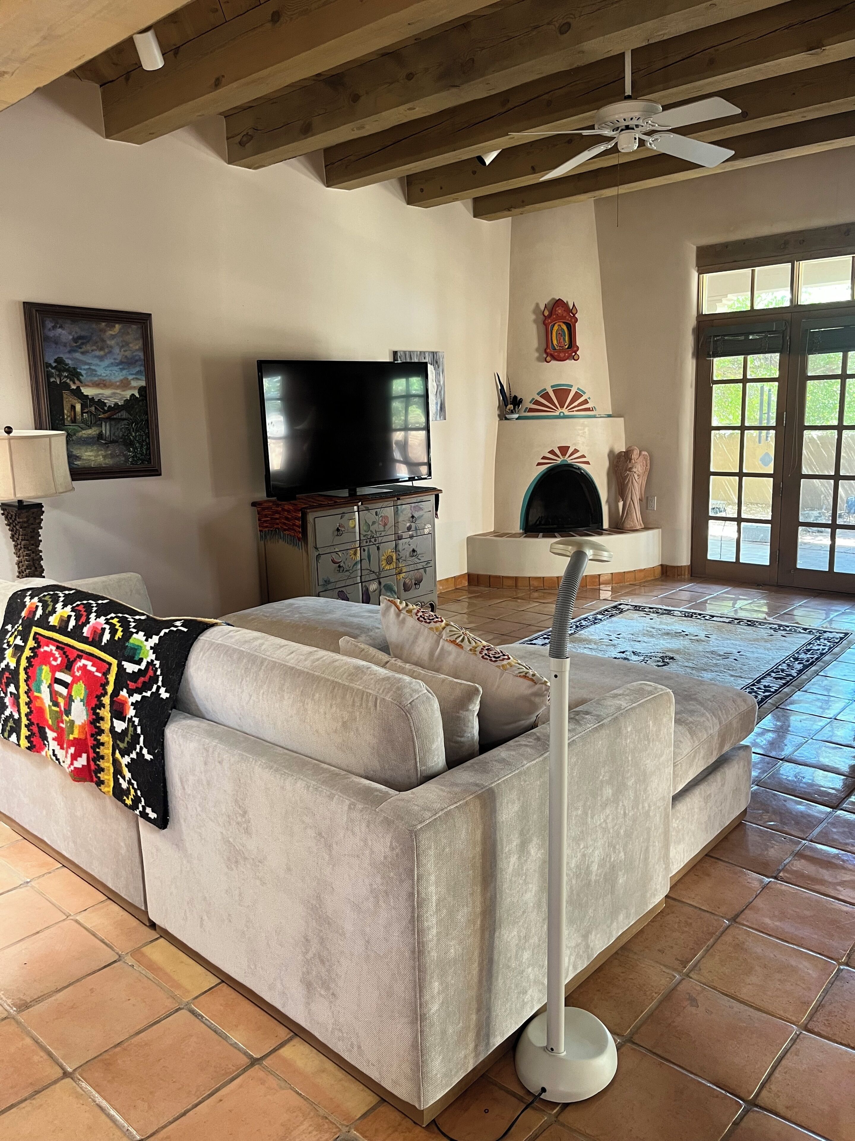 A living room with a sofa, a television, and a fireplace.