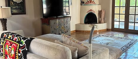 Un salon avec un canapé, un téléviseur et une cheminée.