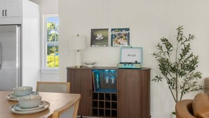 Eine moderne Küche mit Esstisch, einem Holzschrank mit einem Vintage-Radio und einer Topfpflanze.