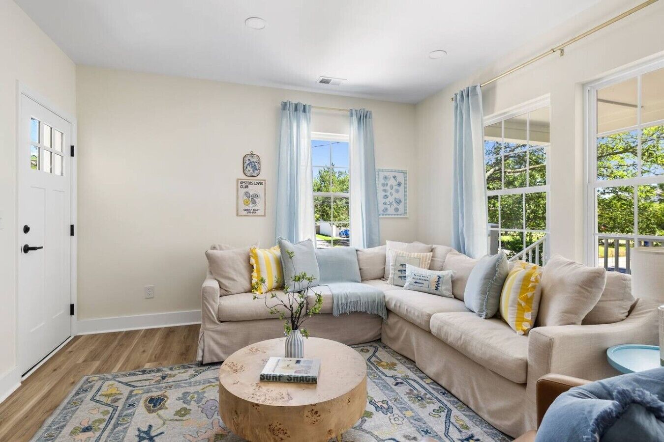 A living room with a beige sofa, a round coffee table, and a patterned rug.