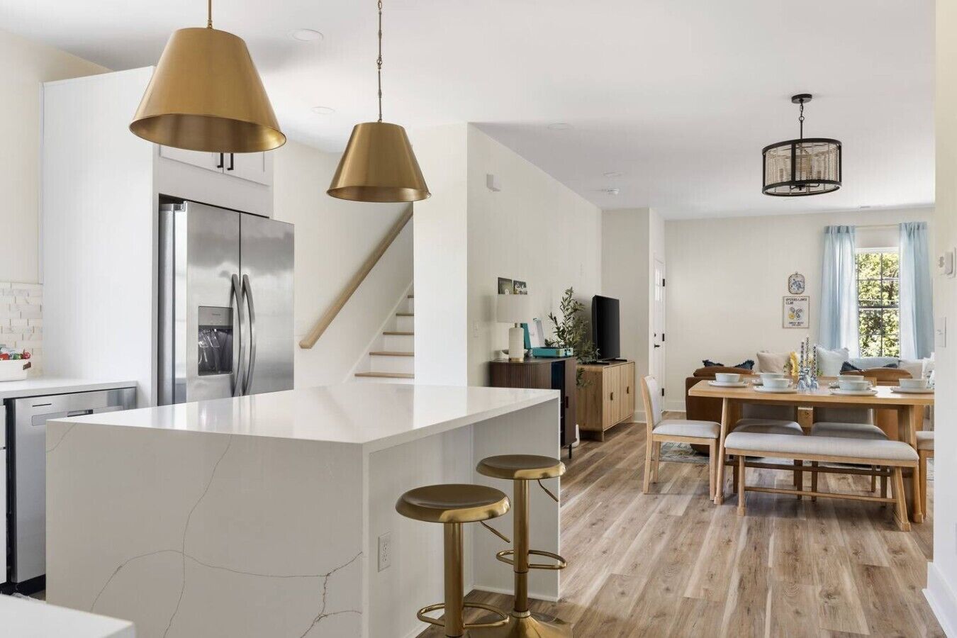 A modern kitchen with a central island, stainless steel appliances, and pendant lighting.