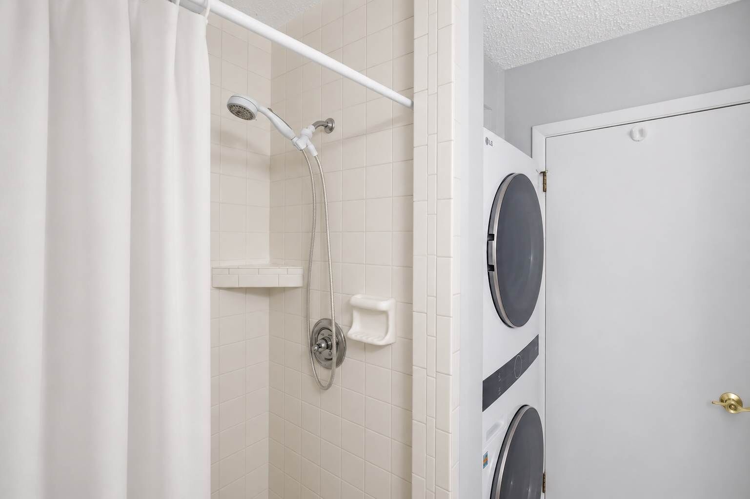 Une salle de bain avec une douche, des toilettes et un lave-linge.