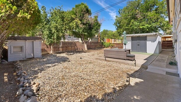 A backyard with a patio, a shed, and a fenced area. - Sleek & Modern 1BR/1BA Reno Home (Reno)