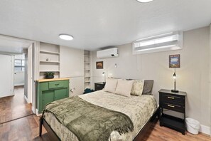 Ein Schlafzimmer mit Bett, Nachttischen, einem Kleiderschrank und einer eingebauten Regallösung.