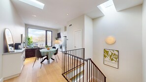 Un appartamento moderno con zona pranzo, cucina e scala.