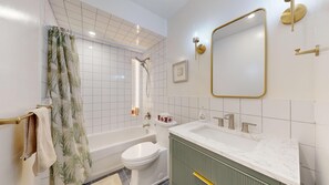 Een moderne badkamer met een bad, toilet en wastafel.