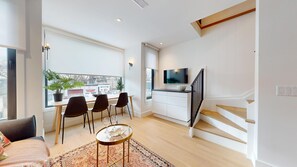 A modern apartment with a dining area, kitchen, and living space.