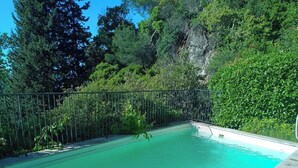 A rectangular swimming pool with clear blue water, surrounded by a metal fence and stone tiles. - Stunning villa with a pool and ocean view, Mediterranean garden, sleeps 8 (Grasse)