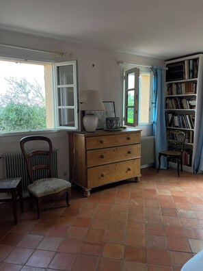A room with a wooden dresser, a chair, a radiator, a bookshelf, and a window with curtains. - Stunning villa with a pool and ocean view, Mediterranean garden, sleeps 8 (Grasse)